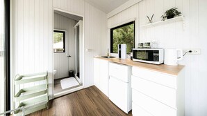 A modern kitchen with white cabinetry, a wooden countertop, and a microwave. - Forest View Cottage 1 (森林景觀度假小屋1) (Jiaoxi Township)