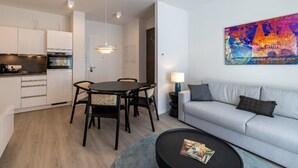 A modern apartment with a dining area, kitchenette, and living space. - Atlantic Grand Hotel - Appartement (Lübeck)