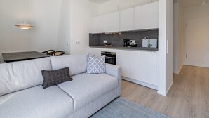 A modern kitchen with white cabinets, a grey countertop, and a built-in oven. - Atlantic Grand Hotel - Appartement Plus mit Balkon Oder Veranda (Lübeck)