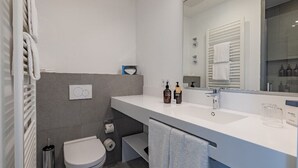 A modern bathroom with a white sink, mirror, and towel rack. - Atlantic Grand Hotel - Appartement Plus mit Balkon Oder Veranda (Lübeck)