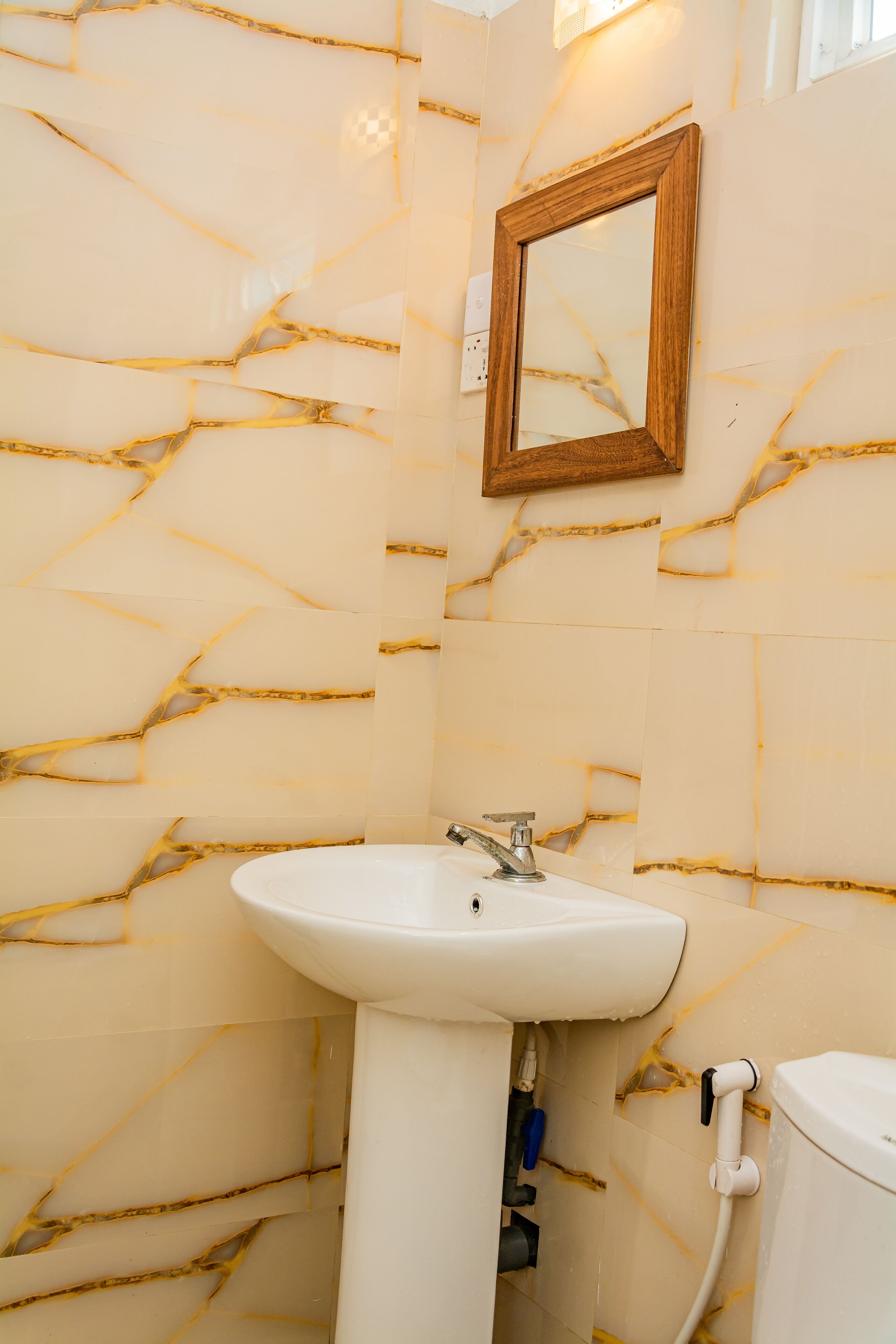 Un bagno con un lavandino bianco, uno specchio e un water.