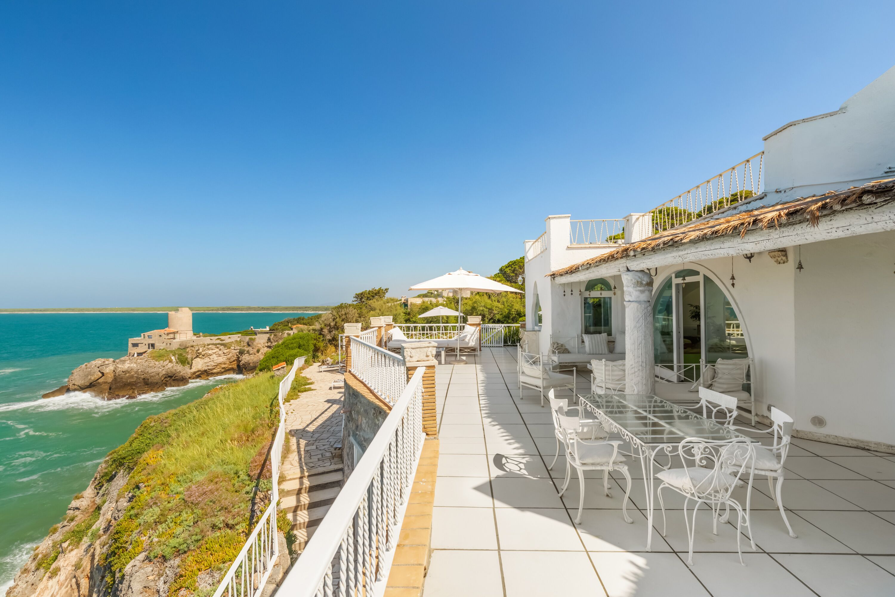 Una proprietà costiera con terrazza vista mare, con area salotto all'aperto e vista sull'oceano.