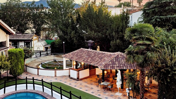 Uma área de pátio com piscina, mobiliário para área externa e vista da paisagem ao redor.