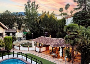 Un patio con piscina, mobiliario exterior y vistas del paisaje circundante.