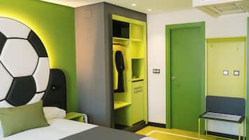 Habitación de hotel con cama, pared verde, armario con letrero de hidratación y puerta verde.