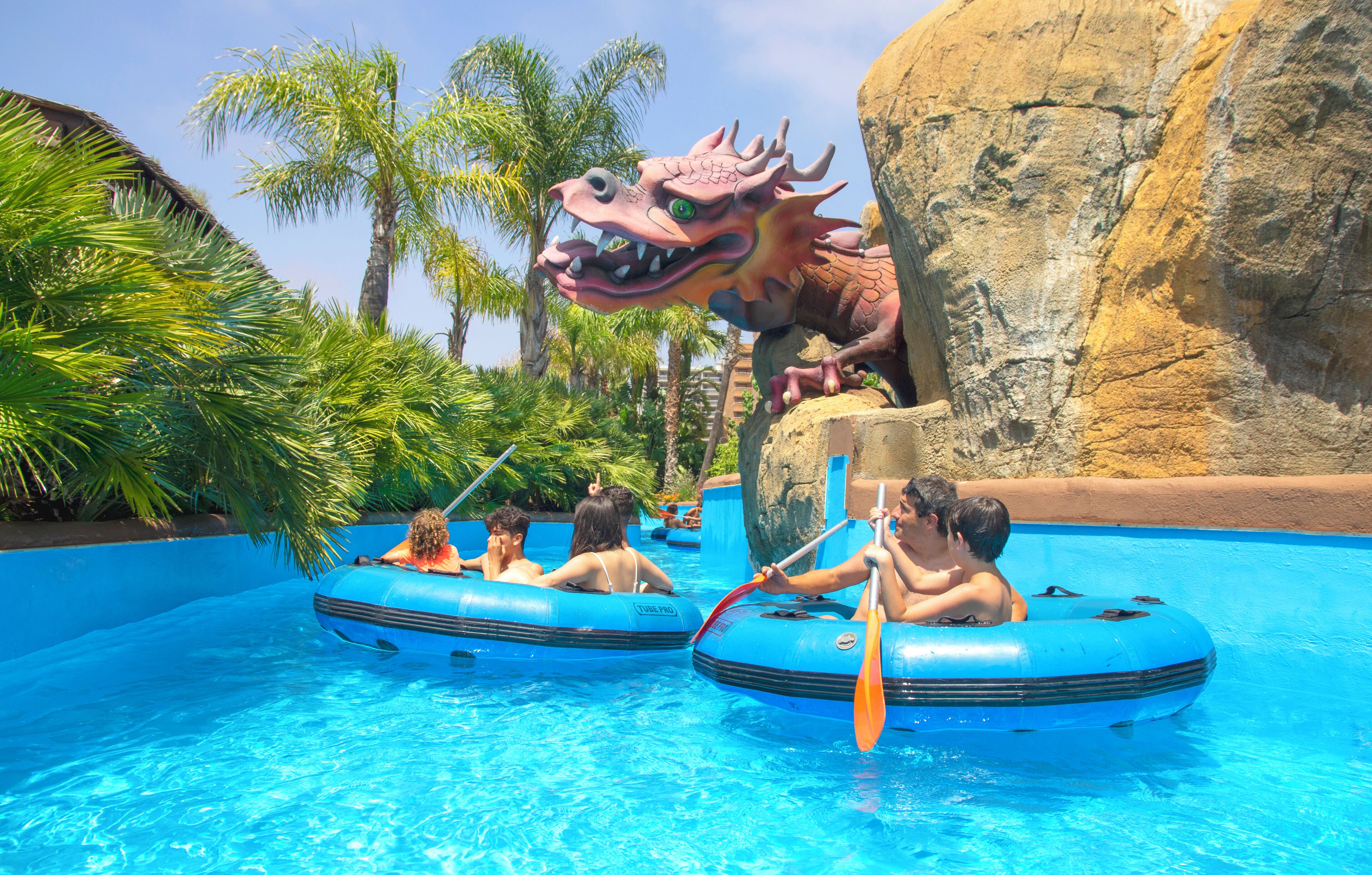 Una piscina con balsas inflables y una gran estatua de dragón.