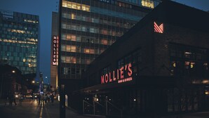 A building with a sign reading 'MOLLIE'S BAR & DINER' and a large illuminated 'MOLLIE'S' sign on the side. - Mollie's Manchester (Manchester)