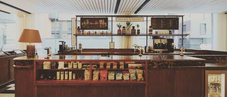 A bar area with a checkered floor, wooden counter, and shelves with various items.