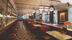 A restaurant with a long counter, booths, and a tiled floor. - Mollie's Manchester (Manchester)