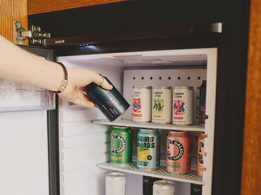 A refrigerator with multiple shelves containing various beverage cans.