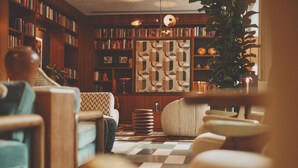 A cozy living room with a checkered floor, a bookshelf, and a patterned wall divider. - Mollie's Manchester (Manchester)