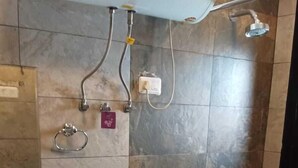 A bathroom with a toilet, sink, and shower. - Silver Oak (Srinagar)