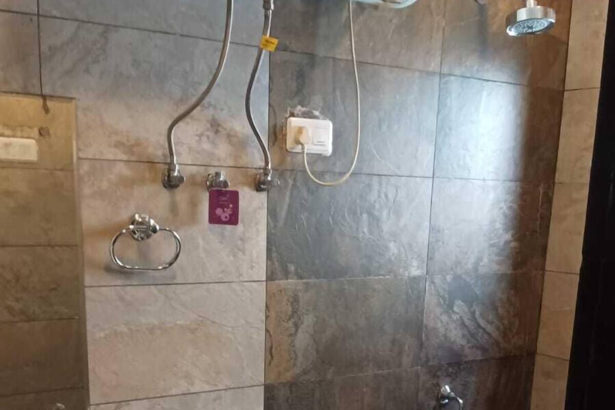 Casa de banho com sanita, lavatório e chuveiro.