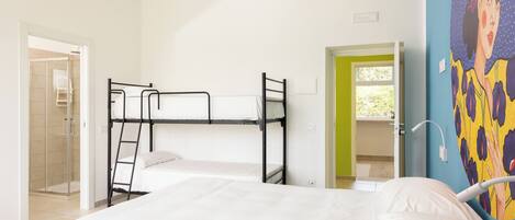 A room with a bunk bed, a shower area, and a door leading outside.