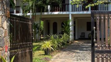 A two-story building with a stone pathway leading to a gated entrance.