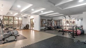 A gym with exercise equipment, large windows, and a tiled floor. - vacationhomesng (Lagos)
