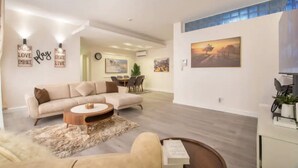 A modern living room with a sofa, coffee table, and artwork on the walls. - vacationhomesng (Lagos)