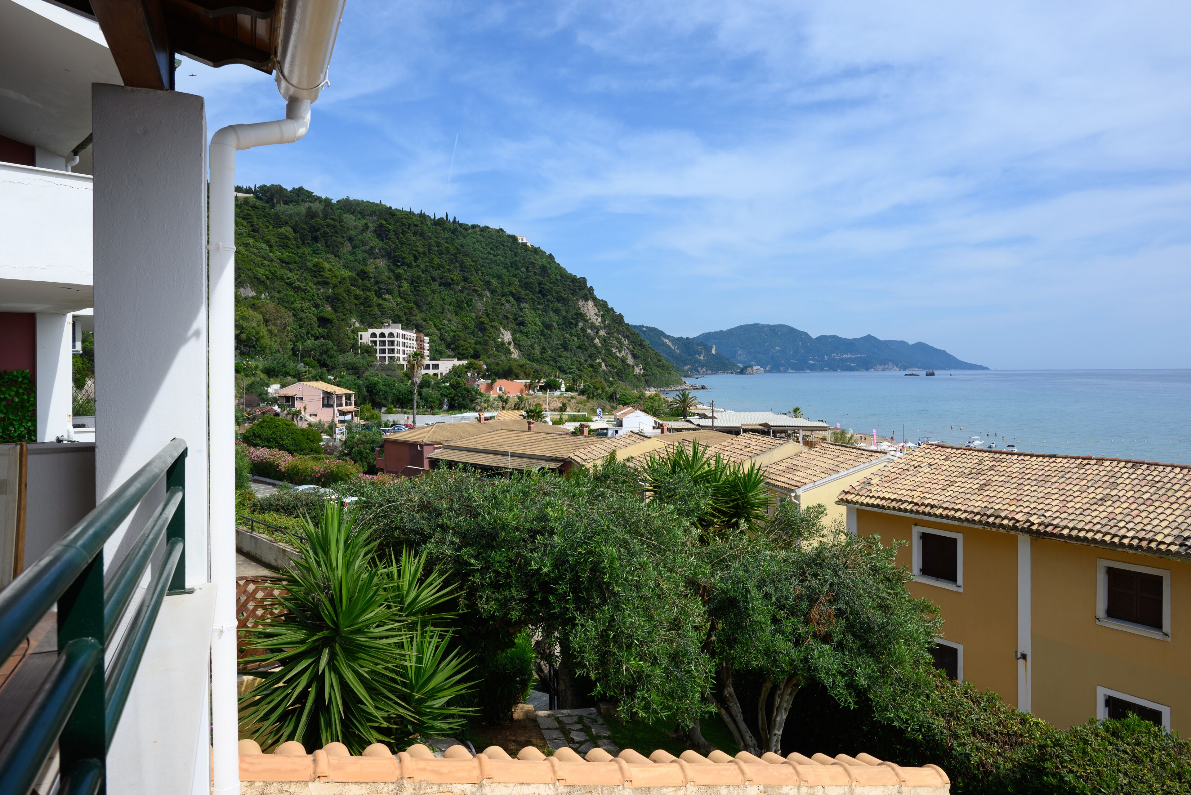A coastal town with buildings, a sea view, and a hillside.