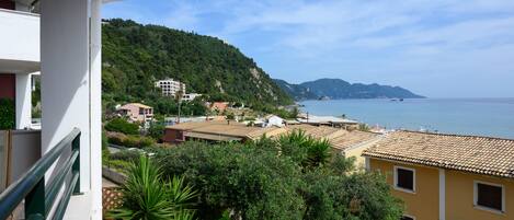 A coastal town with buildings, a sea view, and a hillside.