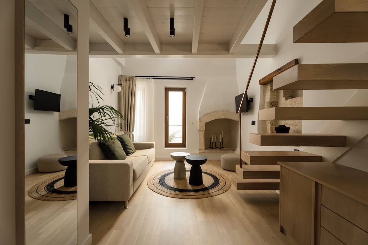 A modern living room with a sofa, coffee table, and a fireplace.