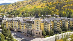 A multi-story hotel with a central courtyard, surrounded by autumn-colored trees and a mountainous backdrop. - Ritz-Carlton Residence Club Vail, CO Luxury 3 Bedroom 
Condo Resort- Sleeps 8 (Vail)