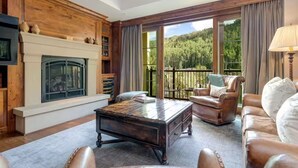A spacious living room with a fireplace, leather furniture, and a balcony with a scenic forest view. - Ritz-Carlton Residence Club Vail, CO Luxury 3 Bedroom 
Condo Resort- Sleeps 8 (Vail)