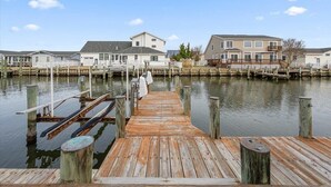 A wooden dock leading to a marina with houses on stilts. - Five Bedroom Waterfront Home with Lots of Space (Ocean City)