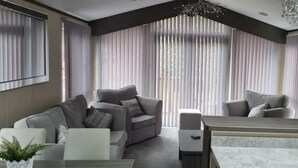 A modern living room with a sofa, armchairs, and a marble coffee table. - Stunning 3-bed Lodge in Windermere (Windermere)