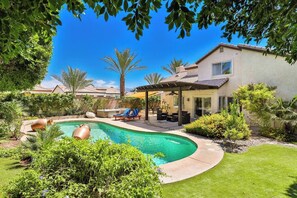A residential property with a swimming pool, outdoor seating, and a covered patio area. - Private Saltwater Pool & Hot Tub Oasis w/ WiFi (La Quinta)