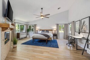 A modern bedroom with a bed, bedside tables, a desk, and a ceiling fan. - Private Saltwater Pool & Hot Tub Oasis w/ WiFi (La Quinta)