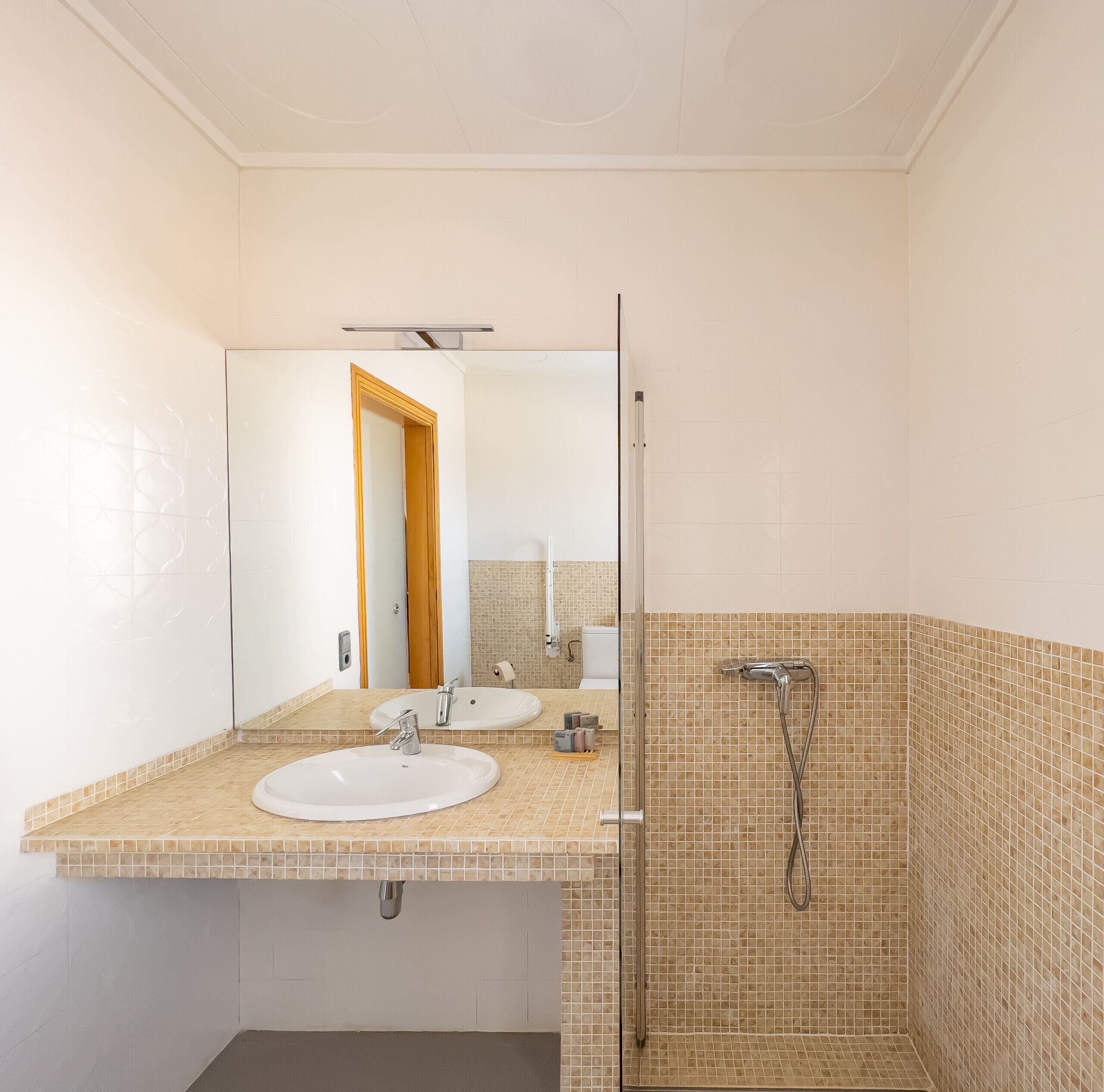 Ein Badezimmer mit Waschbecken, Spiegel und Dusche.