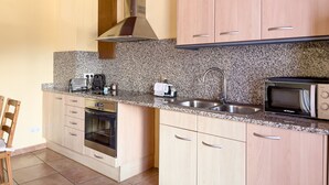 A modern kitchen with granite countertops, stainless steel appliances, and wooden cabinets.
