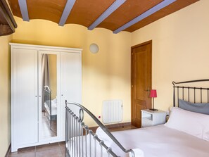 Relax in a cozy space with a comfortable bed, bedside table, and wardrobe.