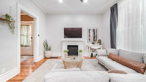 Una sala de estar moderna con chimenea, un sofá, una mesa de centro y una televisión.