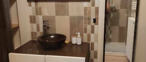 A bathroom with a sink, mirror, and a toilet.