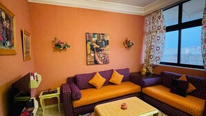 A living room with a sofa set, a coffee table, a television, and a patterned rug. - Beautiful Studio in the heart of Casablanca (Casablanca)