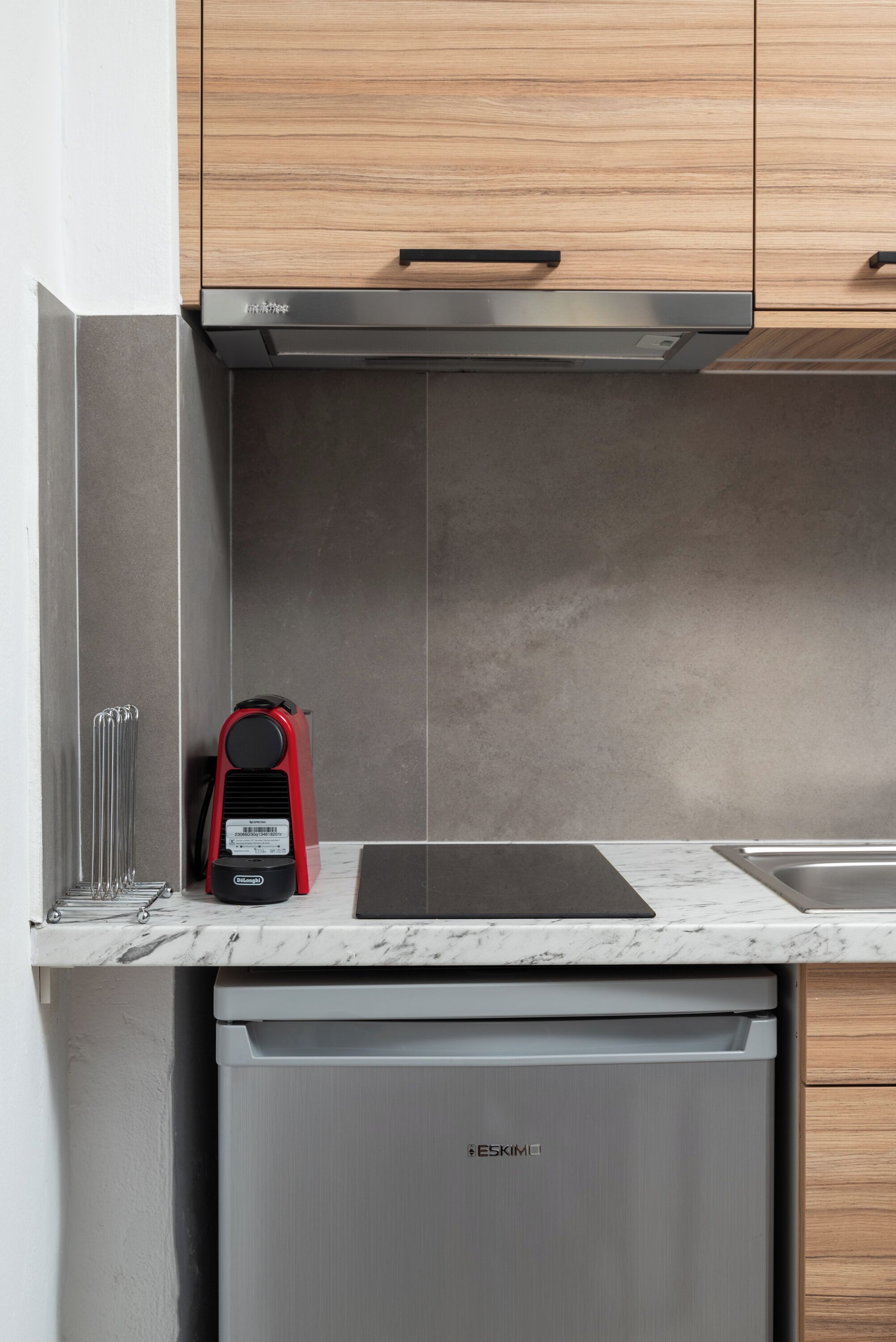 Una cocina moderna con armarios de madera, un microondas integrado y un lavavajillas.