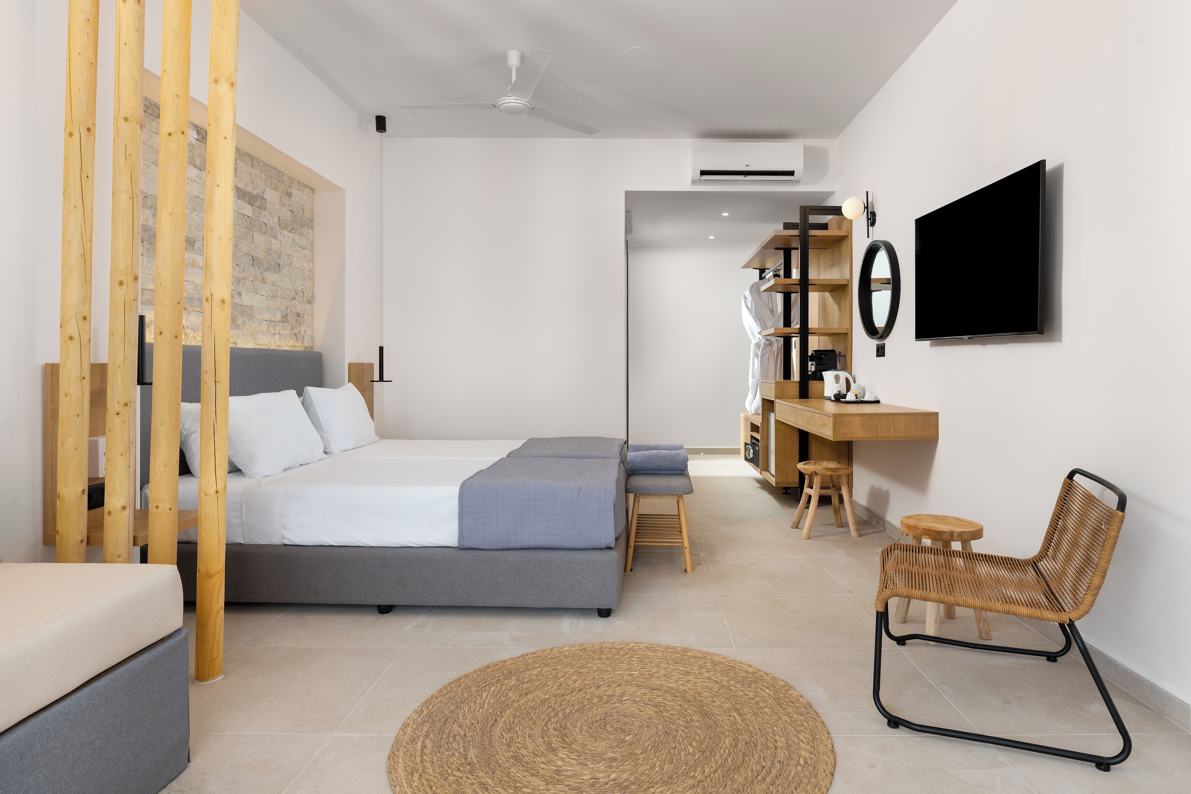Une chambre à coucher moderne avec un lit, un bureau, une chaise et un téléviseur.