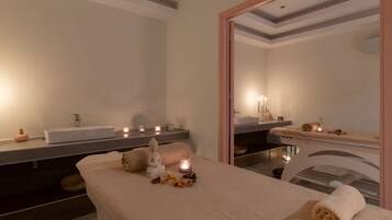 Relax in a serene spa room with a large mirror, vanity area, and massage table.