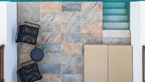 A top-down view of a room with a tiled floor, a sofa, a chair, and a small table. - Costa Lindia Beach Resort (Rhodes)