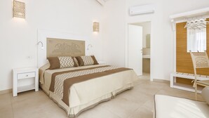 A bedroom with a bed, bedside tables, a wardrobe, and a bench.
