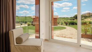 A room with a large sliding glass door leading to a vineyard view.