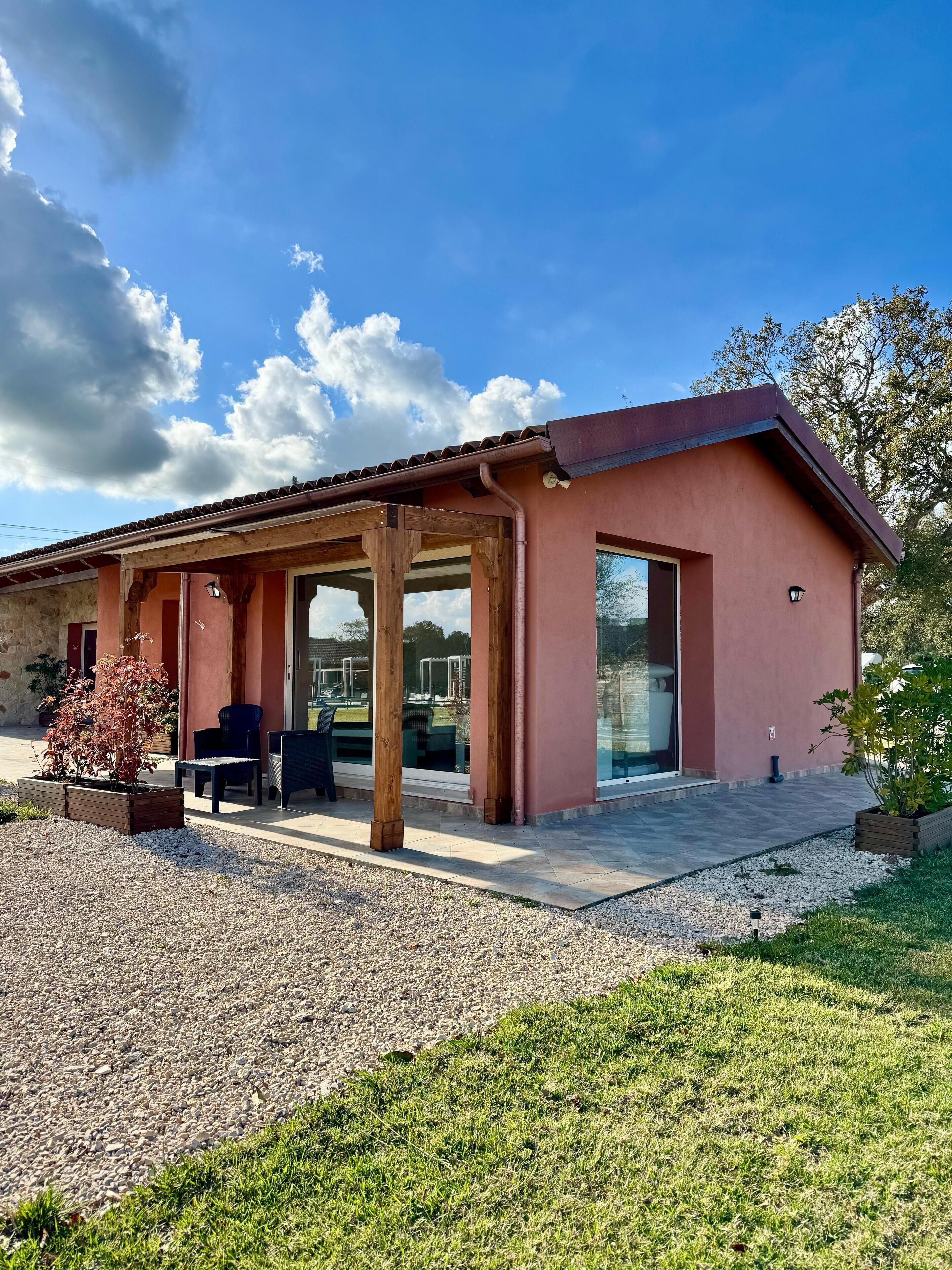 Una casa moderna con un patio, mobiliario exterior y vistas al jardín trasero.