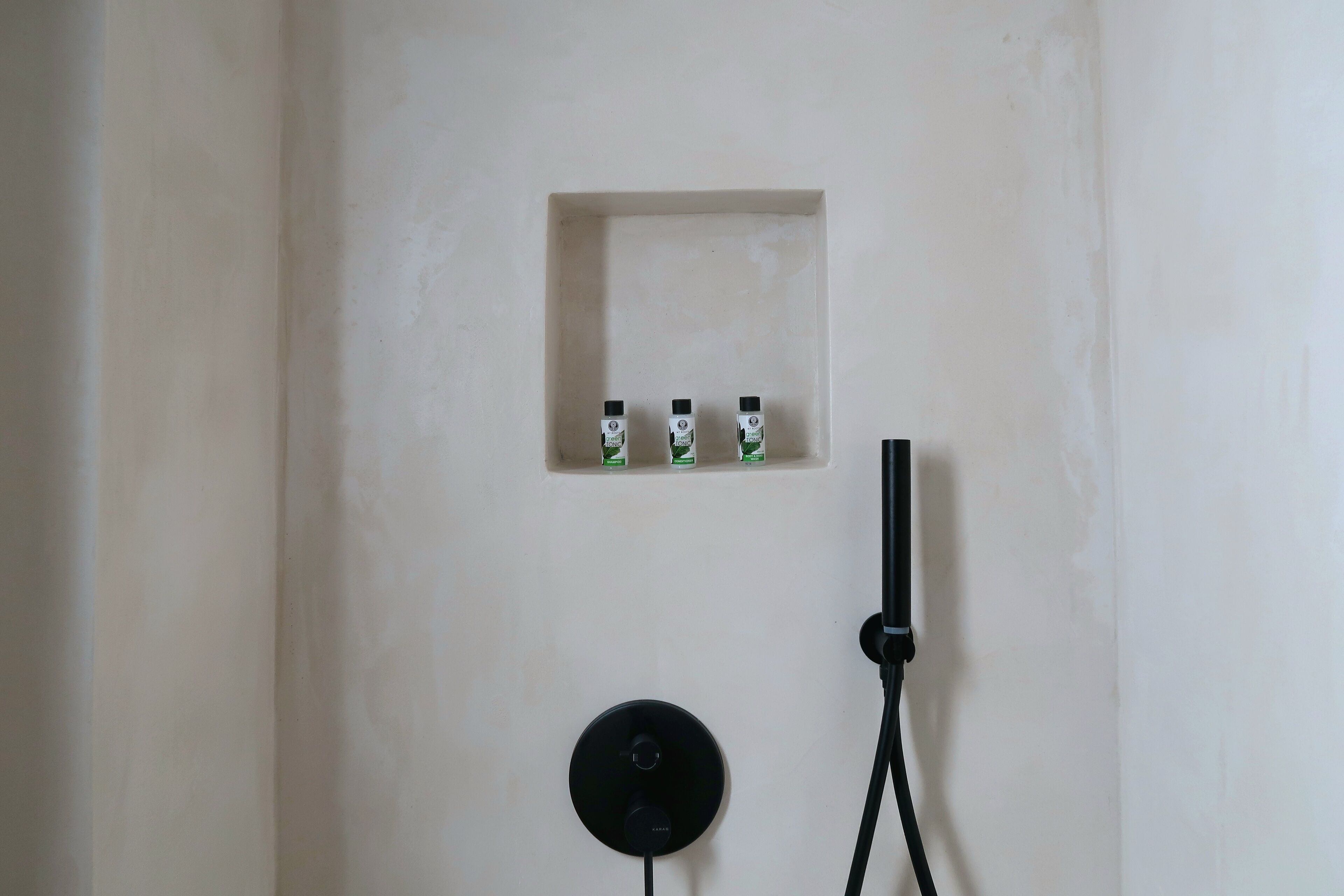 Una presa elettrica a muro con ciabatta e tre piccoli contenitori.