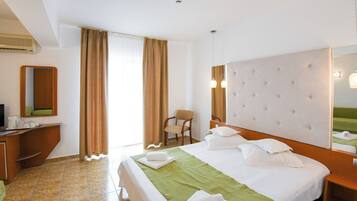 Una habitación de hotel con una cama, una silla, un escritorio y un espejo.