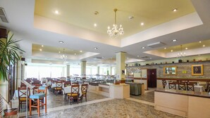 A spacious hotel lobby with marble flooring, multiple dining areas, and a central reception desk. - Complex Modern Mamaia All Inclusive (Constanta)