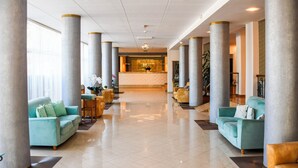 A spacious lobby with a reception desk, large columns, and seating areas. - Complex Modern Mamaia All Inclusive (Constanta)