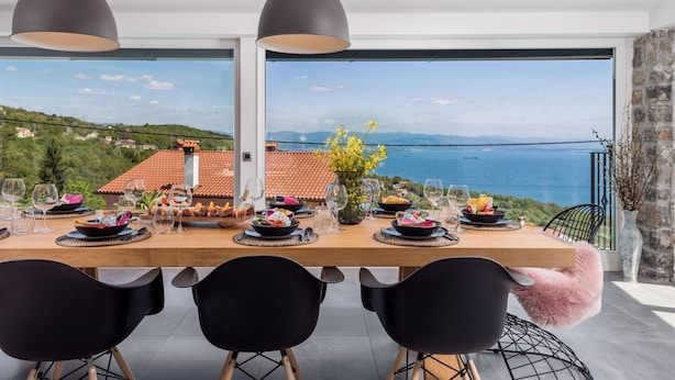 A dining table set with plates, glasses, and cutlery, overlooking a scenic coastal view. - Casa Mills, luxury 4 bedrooms house near Opatija (Poljane)