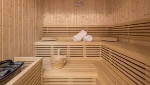 Puisesta laudelavasta tehty sauna, pyyhepenkki ja ämpäri.