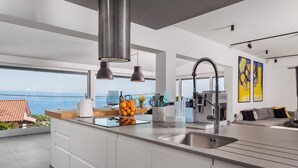 A modern kitchen with a large island, stainless steel appliances, and a view of the sea. - Casa Mills, luxury 4 bedrooms house near Opatija (Poljane)